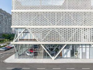 The front view of the Wuxi Xibaohang BMW 4S dealership, where LOPO white ceramic bricks create an elegant and modern appearance, in harmony with the building's surrounding environment.