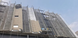 A close-up view of the on-site installation process of LOPO Terracotta panels, showcasing the structural integrity and precision engineering of the curtain wall system.