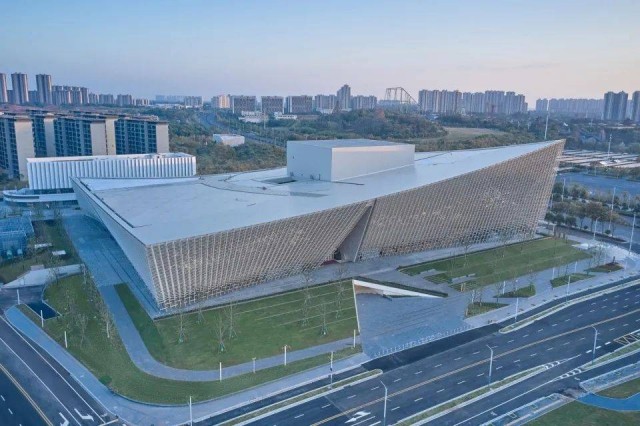 Aerial view of Nanchang Poly Grand Theatre highlighting its terracotta - clad exterior and the surrounding urban landscape.