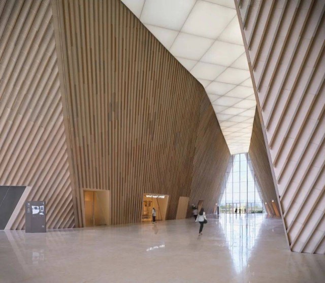  Interior view of Nanchang Poly Grand Theatre with sunlight filtering through terracotta baguettes, creating a warm and inviting atmosphere.